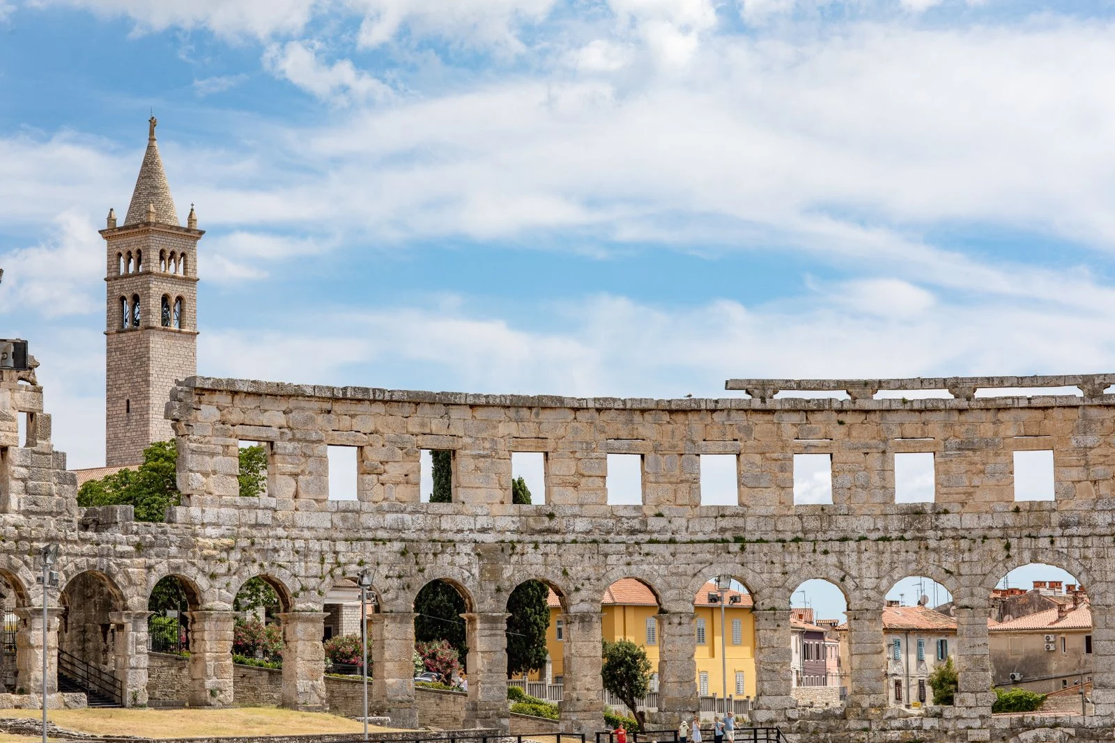 Limestone arches of Pula Arena beneath a blue sky