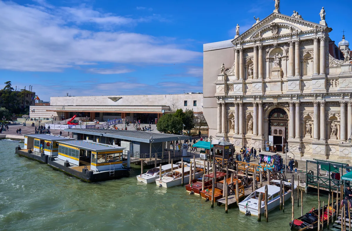 Water bus stops signed Ferrovia on the Venice waterfront, with water taxis moored alongside